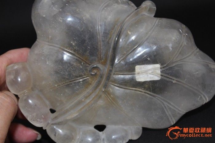 【拍品描述】天然水晶雕荷叶莲藕水盂.高5cm.径16cm.重500g.全品.包是天然水晶.雕一卷曲的荷叶,一朵莲花两支花蕾,弯弯的莲藕上蛙声一片.造形生动优美.极具文人气息. 【友情提示】:在这秋高气爽的金秋,古明专场又与大家见面了,欢迎各位朋友的光临!本人严格遵守华夏拍卖规则,不用马甲,不搞假拍,7日内无条件退货<但请支付双向邮资>.